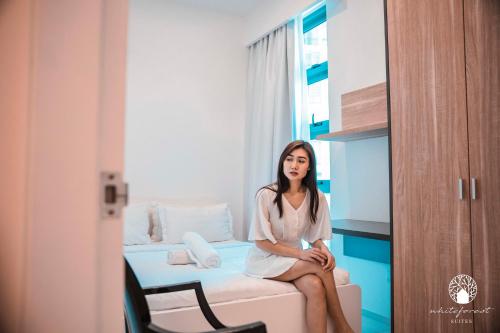 a woman sitting on a bed in a room at The Robertson Kuala Lumpur by White Forest Suites in Kuala Lumpur