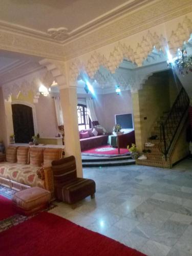 a large living room with couches and a staircase at guest house le petit jardin 2 in Marrakech
