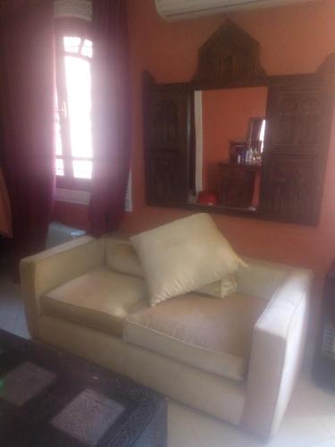 a white couch in a living room with a window at guest house le petit jardin 2 in Marrakech