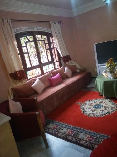 a living room with a couch and a window at guest house le petit jardin 2 in Marrakech