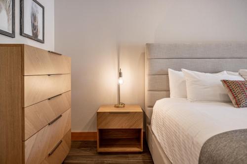 a bedroom with a bed and a dresser with a lamp at Alpen Dorf Pension in Leavenworth