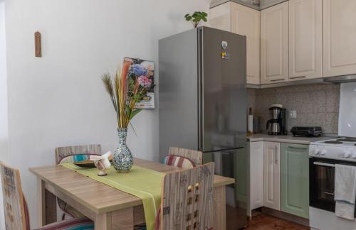 a kitchen with a table with a vase of flowers on it at Ornella's & Laura's secret place in Livadia