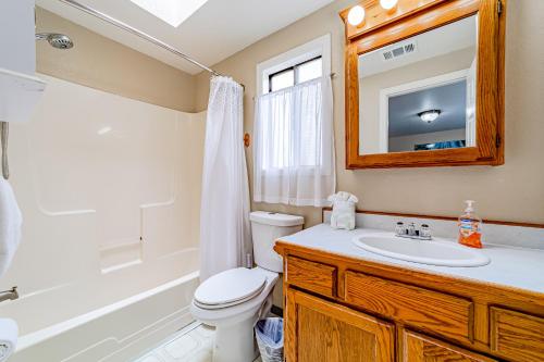 a bathroom with a toilet and a sink and a mirror at Serenity By The Sea in McKinleyville