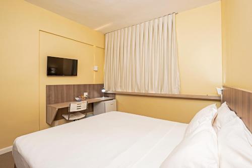 um quarto de hotel com uma cama e uma televisão em Slim Cuiabá Aeroporto by Slaviero Hotéis em Várzea Grande