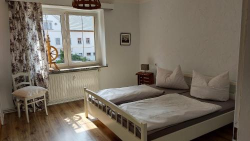 een slaapkamer met een bed met witte lakens en een raam bij Roter Milan in Kaisitz