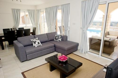 a living room with a couch and a table at Club St. George in Paphos City