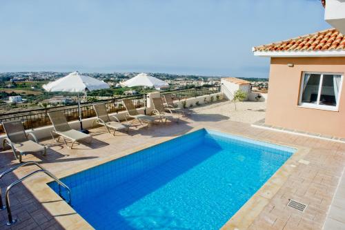 a swimming pool on the roof of a house at Club St. George in Paphos City