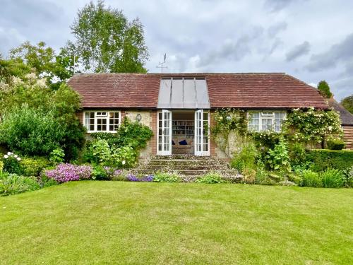 a small stone house with a large yard at Library Cottage in Thakeham