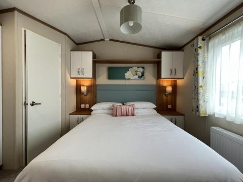 sypialnia z dużym białym łóżkiem i oknem w obiekcie Stewarts Resort Lodge 21 w mieście St Andrews