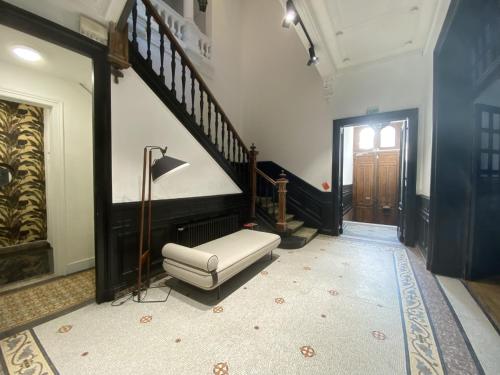 a living room with a stairway with a chair and a stairway at Maison Mimerel Colodge in Roubaix