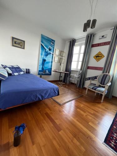 1 dormitorio con 1 cama azul y suelo de madera en MyVilla B&B, en Palazzo Canavese