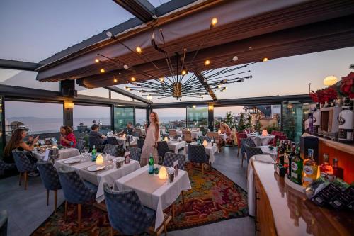un restaurante con mesas blancas y gente sentada en mesas en Tria Hotel Istanbul-Special Category, en Estambul