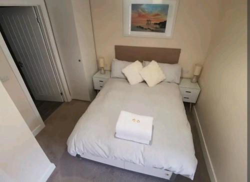a small bedroom with a white bed with two night stands at Griffin 2 Apartments in Nottage
