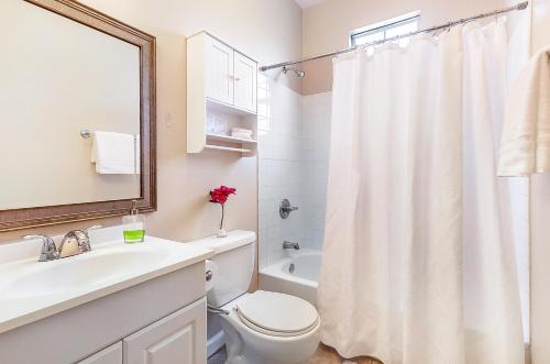 a white bathroom with a toilet and a sink at Cozy Historic 2BR House 10 Min to French Quarter in New Orleans