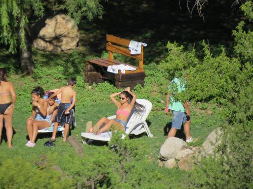 a group of people sitting in the grass at Los Ancares Resort in Mina Clavero