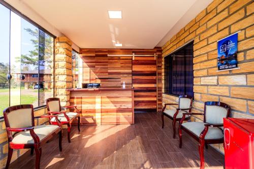 a room with chairs and a stone wall at Pousada Equilíbrio dos Canyons in Praia Grande
