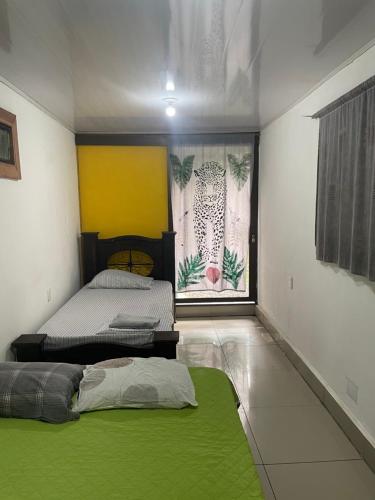 a bedroom with two beds and a green rug at Orgánico Punta Riel in Cahuita