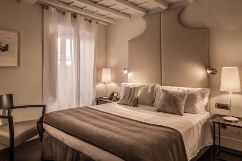 - une chambre avec un grand lit et une fenêtre dans l'établissement 47LuxurySuites - Trevi, à Rome