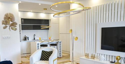 a living room with a white kitchen with a tv at Luxury Apartment Karic FREE parking in Tuzla
