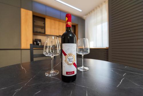 una botella de vino sentada en una mesa con dos copas de vino en Sara, en Bucarest