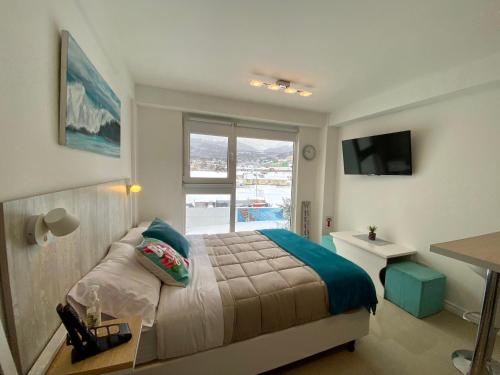 1 dormitorio con cama, ventana y escritorio en AIRES DEL SUR en Ushuaia