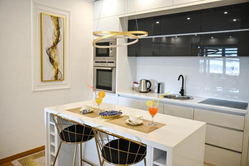 a kitchen with a white island with two glasses on it at Luxury Apartment Karic FREE parking in Tuzla