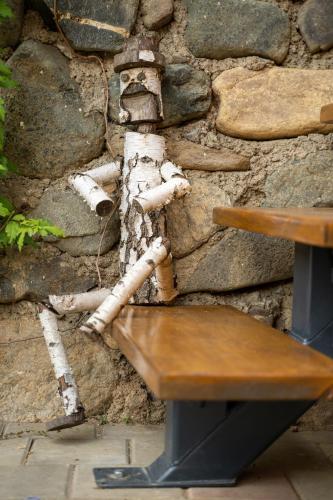 a wooden bench sitting in front of a stone wall at Apartament Panoramic la casa in comuna Rasinari in Răşinari