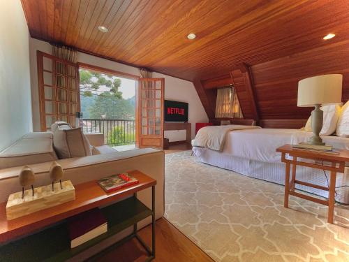 カンポス・ド・ジョルドンにあるCasa Três Rios - Campos do Jordãoの広いベッドルーム(ベッド1台、窓付)