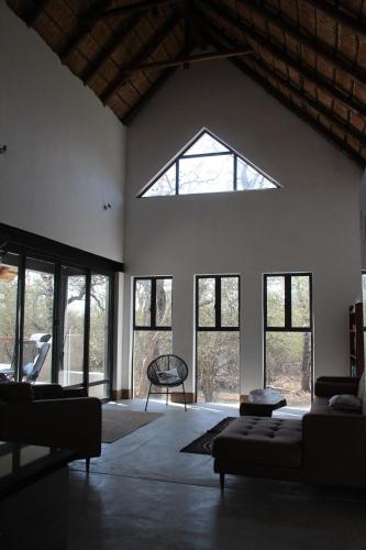 - un salon avec une grande fenêtre et un canapé dans l'établissement Marloth Park, Kruger safari house - solar, à Marloth Park