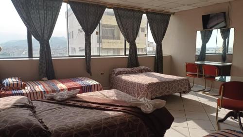 Habitación de hotel con 2 camas y ventana en Hotel Sol de Oro en Guayaquil