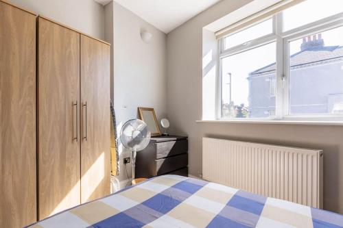 sypialnia z łóżkiem i oknem w obiekcie Spacious 2 bed Apartment with FREE PARKING for 2 cars and underground station Zone 2 for quick access to Central London up to 8 guests w Londynie