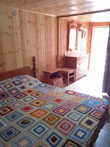 a bedroom with a bed with a colorful quilt on it at La Tua Casa a Roccaraso in Roccaraso