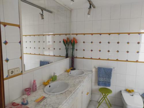 La salle de bains est pourvue de 2 lavabos et d'un miroir. dans l'établissement Encantadora casa con piscina privada y vistas panorámicas, à Castellar de Santisteban