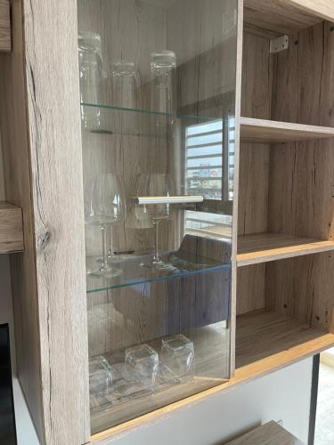 a wooden cabinet with glasses in it at Luxury Flat in Casa Finance City in Casablanca