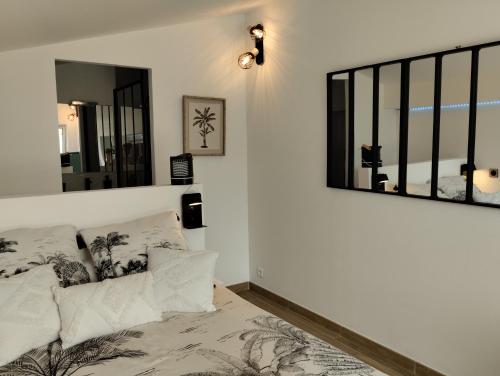 1 dormitorio con cama y espejo en la pared en L'Atelier Saint-Sulpice entre Bordeaux et St Emilion, en Saint-Sulpice-et-Cameyrac