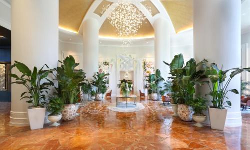 eine Lobby mit Topfpflanzen und einem Kronleuchter in der Unterkunft InterContinental Buckhead Atlanta, an IHG Hotel in Atlanta