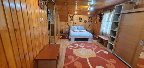 a small room with a bed in a wooden cabin at Casa Cristian in Câmpulung Moldovenesc