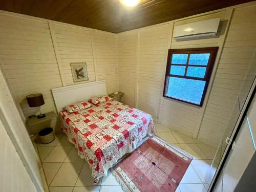 a small bedroom with a bed and a window at Cabana com piscina - 5 min a pé da praia - Porto Belo in Porto Belo
