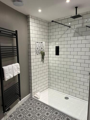 bagno con doccia e parete piastrellata bianca di Grayling Cottage ad Ambleside
