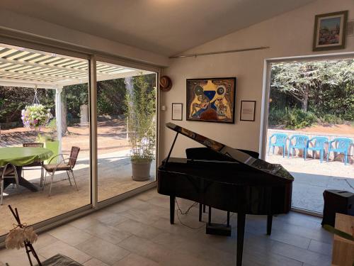 a room with a piano and a baseball bat in it at Chalet banane devant piscine, a 6km du festival de piano de la roque d'anthéron in Rognes