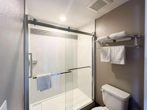 a bathroom with a shower and a toilet with a glass door at Motel 6 Los Angeles, CA - Downtown in Los Angeles