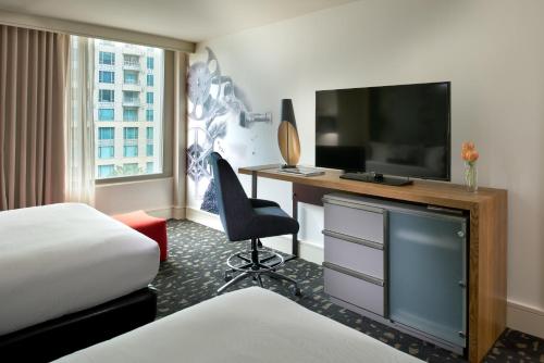 a hotel room with a desk with a television and a bed at Kimpton Hotel Palomar Los Angeles Beverly Hills by IHG in Los Angeles