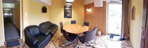 a dining room with a table and black chairs at Komfort Hotel Platan in Harkány