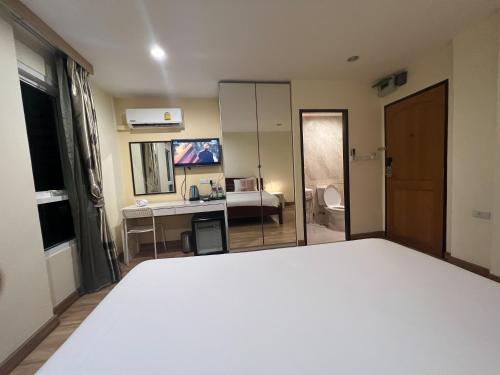 a bedroom with a bed and a desk and a bathroom at V Check inn Sukhumvit 22 in Bangkok