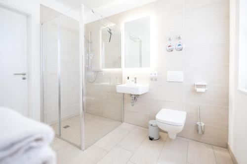 uma casa de banho com um chuveiro, um WC e um lavatório. em Ko-Living - Captain's Suite - Altstadt - mit Küche, Smart TV & Balkon - 6P em Halle an der Saale