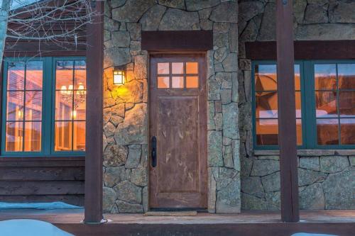 a stone house with a wooden door and windows at Cabin in the Heart of Town - Big Sky in Big Sky