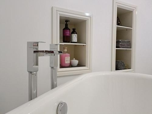 a bathroom with a bath tub and a sink at Keepers Retreat in Rowlands Castle