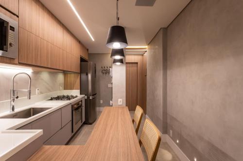 a kitchen with a long wooden table and a sink at Loft Boutique no melhor ponto de Copacabana in Rio de Janeiro