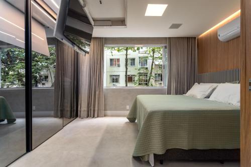 a bedroom with a bed and a large window at Loft Boutique no melhor ponto de Copacabana in Rio de Janeiro