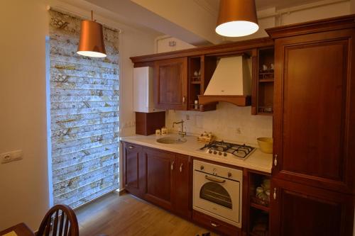 a kitchen with wooden cabinets and a stove top oven at Apartment Stefan in Braşov